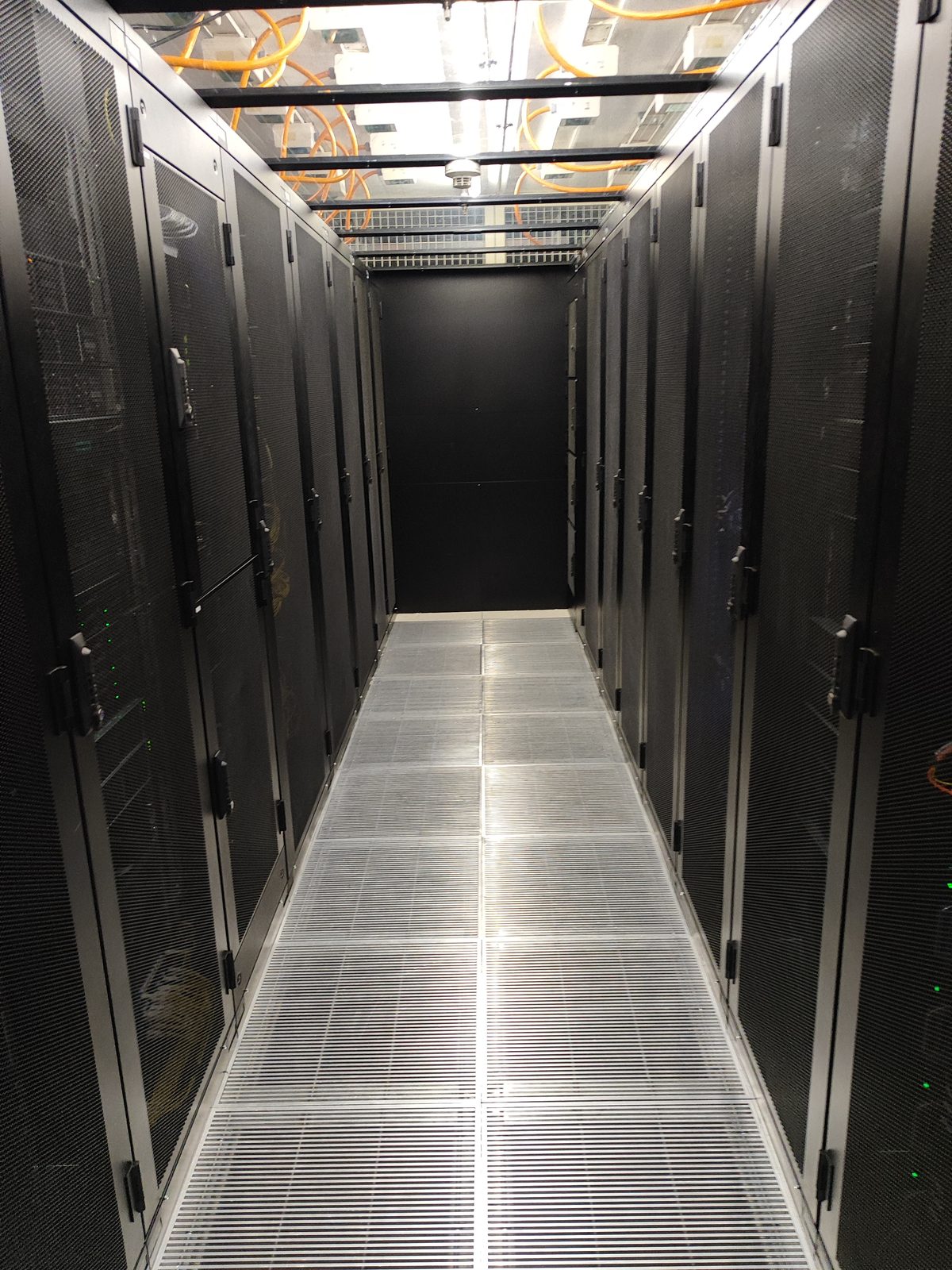 Rows of IT racks in the cold corridor of the standard colocation room at the Crissier datacenter